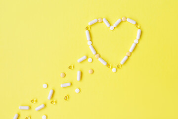 Pills fly and make heart on yellow.