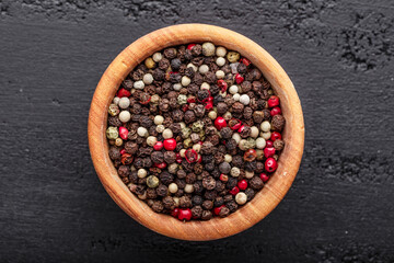 A set of peppers.Collage of different type pepper, Black ,white, pink and allspice peppercornsr, dried chili pepper.Top view. On a black background. free space for your text.