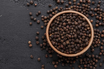 Peppercorn background. Dry black pepper seeds. Top view.On a black background. free space for your...