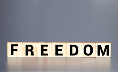Word freedom written on wooden blocks, close up