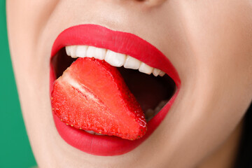Naklejka premium Sexy young woman with strawberry in mouth, closeup