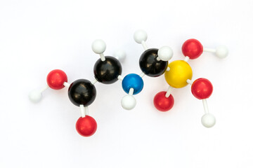 Plastic ball-and-stick model of glyphosate (chemical formula: C3H8NO5P) on a white background....