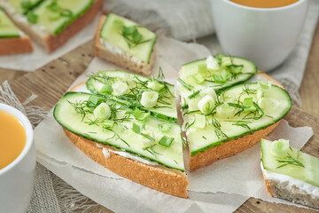 Two sandwiches heart shaped with cream cheese, cucumber and green onion.