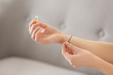 Young woman with perfume sample at home