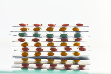 Composition with many pills blister packs lying on each other over white background. Health care, vitamins and treatment concept