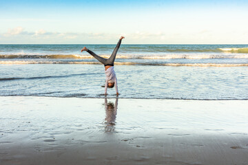 Masked young girl exercising on the beach with pirouettes © Rogerio