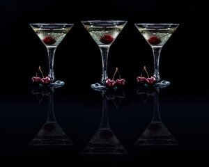 Set of glasses of sweet martini dry cocktail with cherries in black background
