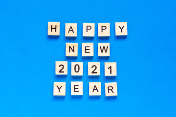 Happy New year written in wooden letters on a blue background. Happy new year 2021. flat layout. space for text. top view.