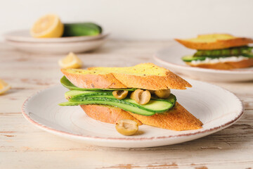 Plate with tasty cucumber sandwich on table