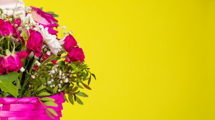 Bouquet with flowers in a basket  on yellow background. Text space