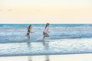 Children running on the beach juggling joy