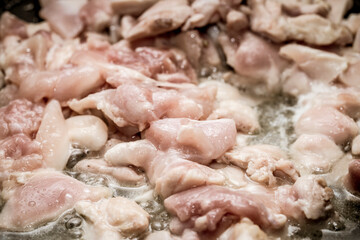 Chicken thigh fillet fried in oil in a pan