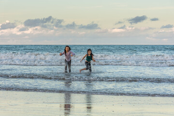 Children running on the beach juggling joy