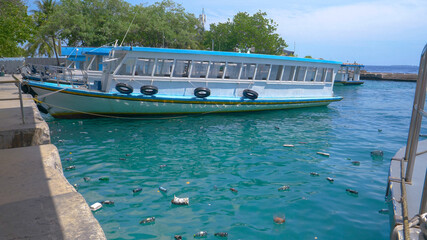 Smelly rubbish floats around the port of Male full of empty tourist boats.
