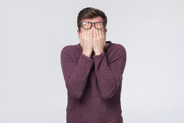 Caucasian man with glasses covering his eyes being tired of working