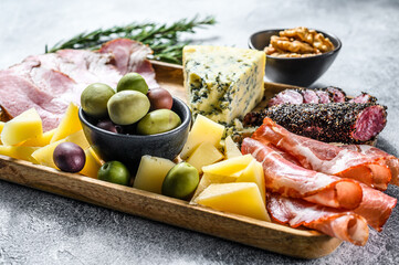 antipasto various appetizer, cutting board with prosciutto, salami, coppa, cheese and olives. Gray background. Top view