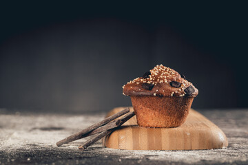 handmade cupcake with chocolate and amaranth on black table, dark food style 