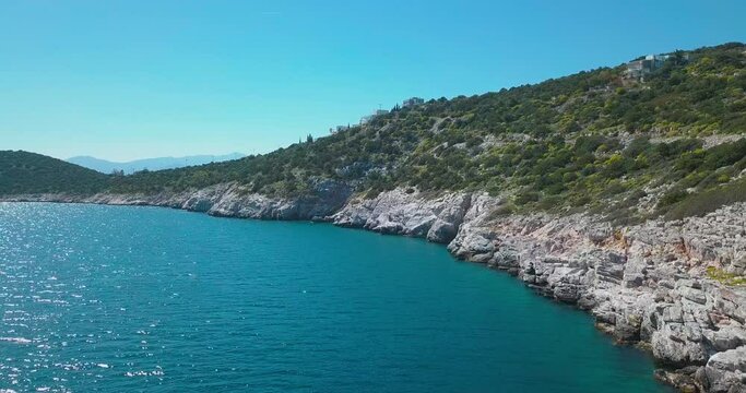 Forward aerial shot next to a rocky shore in the aegean sea. 4K video quality