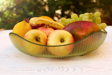 Juicy fruits on a plate on a table on the terrace