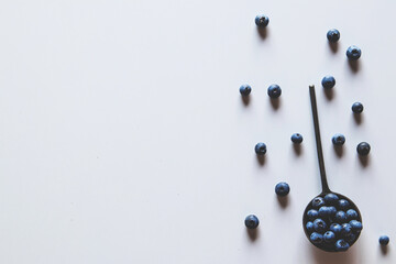 Blueberries in a spoons isolated on a white background. Healthy food, health