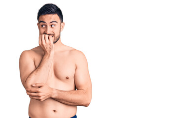 Fototapeta premium Young handsome man wearing swimwear looking stressed and nervous with hands on mouth biting nails. anxiety problem.