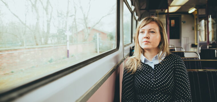 young woman on the train. Young woman on a train looking out the window while sitting during travel on a train. Enjoying travel on train or tube. Young woman on train sitting and relaxing. railroad 