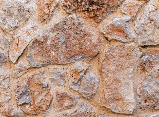 rough brown stone wall close up, seamless textured background