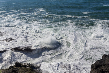 Seawater waves foaming on stones as a background