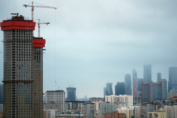 The construction of a high-rise building in the city. Moscow apartments on a foggy morning. Moscow, Russia.