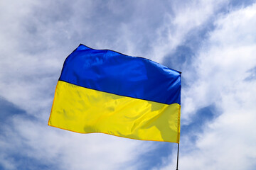 Large national flag of Ukraine flies in the blue sky. Big yellow blue Ukrainian state flag in the Dnepr city, during National Holiday Independence, Constitution Day