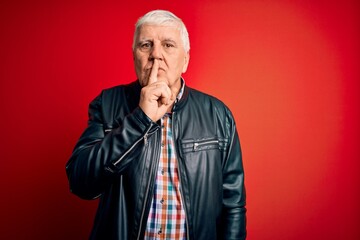 Senior handsome hoary man wearing casual shirt and jacket over isolated red background asking to be quiet with finger on lips. Silence and secret concept.