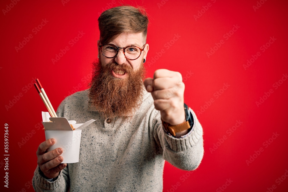 Sticker Redhead Irish man with beard holding box of ramen eating asian food using chopsticks annoyed and frustrated shouting with anger, crazy and yelling with raised hand, anger concept