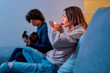 Smoking accessories. Young girl lighting cannabis in glass pipe or bong, relaxing with boyfriend on...