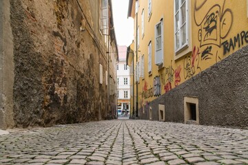 Fototapeta na wymiar An old street with cobblestones and graffiti in Ljubljana, Slovenia