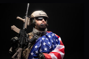Fototapeta premium American special forces against a dark background, a soldier in military equipment holds weapons and the flag of the United States of America, elite troops