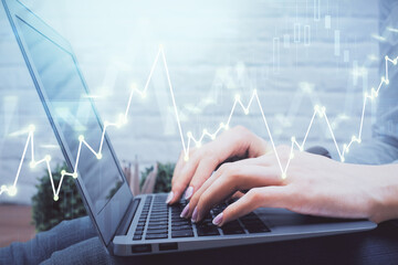 Double exposure of woman hands typing on computer and forex chart hologram drawing. Stock market analysis concept.