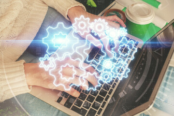Double exposure of woman hands typing on computer and business theme hologram drawing. Success concept.