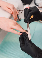 Manicurist at work, beaty manicure nails. Manicure process. Closeup photo shoot of manicure process at beaty studio. Soft focus