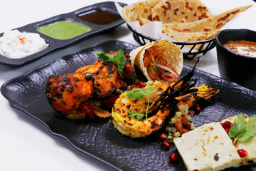 tandoori platter with chicken tikka, grilled prawns, and paneer along with dal makhani, wheat bread and chutneys, Indian food speciality