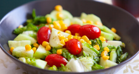 Healthy green salad. bowl of salad with vegetables and greens on table