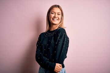 Young beautiful woman wearing fashion urban clothes, model wearing casual street style standing over pink background