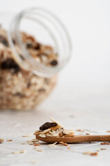 Muesli in a spoon. Muesli in a glass jar. Healthy vegan breakfast or snack. Copy space for text. Proper nutrition concept. Breakfast cereal.. Mixed muesli in wooden spoon. Healthy cereal breakfast.