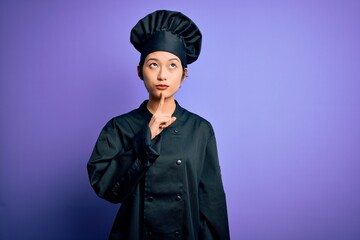 Young beautiful chinese chef woman wearing cooker uniform and hat over purple background Thinking concentrated about doubt with finger on chin and looking up wondering