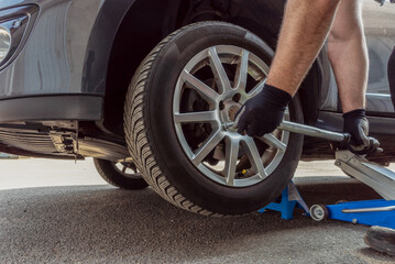 Mechanic changing wheel on a car