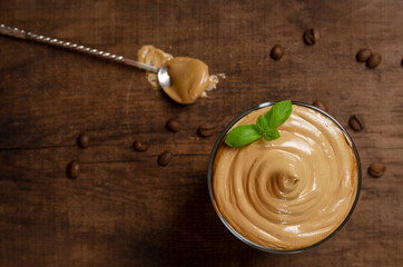 Dalgona Coffee Iced, a Korean whipped black instant coffee with milk, on a dark