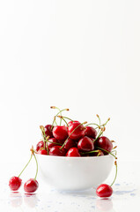 bowl full of sweet cherries on white