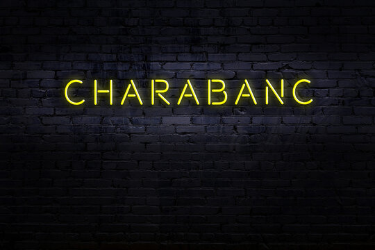 Night view of neon sign on brick wall with inscription charabanc