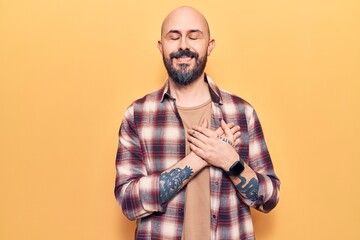 Young handsome man wearing casual clothes smiling with hands on chest with closed eyes and grateful gesture on face. health concept.
