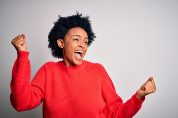 Young beautiful African American afro woman with curly hair wearing red casual sweater Dancing happy and cheerful, smiling moving casual and confident listening to music