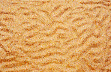Beach sand texture. Summer wallpaper or background image.